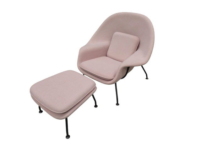 Butaca y reposapiés modelo Womb Chair con estructura de acero en negro. Carcasa y cojines tapizados en lana tono crema. Alquiler para eventos, publicidad, series, películas.