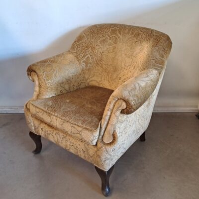 Butaca vintage con tapicería de tela con estampado paisley en tonos beige y marrón. Alquiler para eventos, publicidad, series, películas.