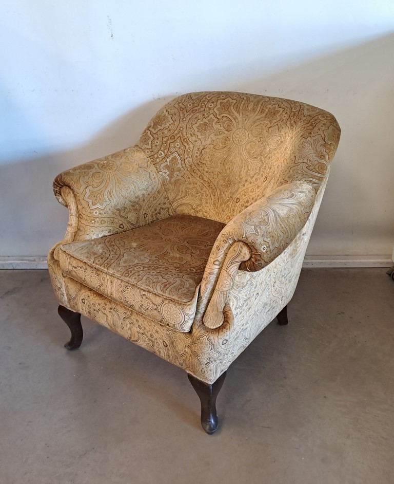 Butaca vintage con tapicería de tela con estampado paisley en tonos beige y marrón. Alquiler para eventos, publicidad, series, películas.
