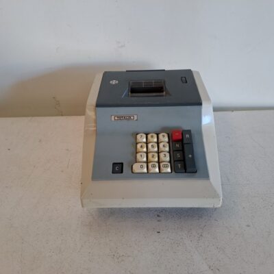 Calculadora sumadora vintage Totalia. Es un modelo de sobremesa con cuerpo de plástico bicolor (crema y gris oscuro). Lagomarsino S.p.A. fabricó estas máquinas, siendo uno de los últimos modelos mecánicos en el mercado hasta 1975. Alquiler para eventos, publicidad, series, películas