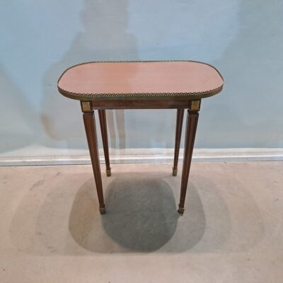 Louis XVI style oval side table. This piece is a Louis XVI style side table, probably made in France in the late 19th or early 20th century. Its design combines classic elegance with ornamental details characteristic of the period. For rent for events, advertising, series, films.