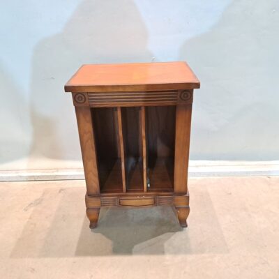 Classic or vintage style side table, designed with three open vertical compartments and curved legs. Due to its characteristics and approximate dimensions, this type of furniture is commonly used as a side table, magazine rack or to organise vinyl records. Rental for events, advertising, series, films.