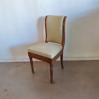 French Empire style dining chair. It features a design that evokes historic European styles of the 19th and early 20th century. The high-backed design and elegant lines are characteristic of styles such as French Empire, Biedermeier or neoclassical. Rental for events, advertising, series, films.