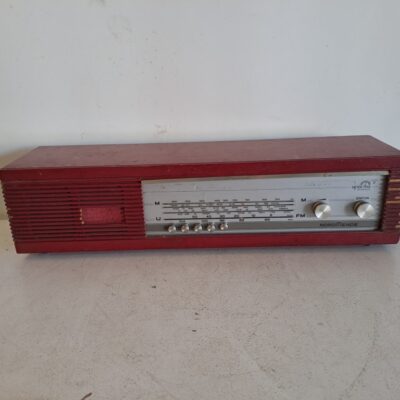 Nordmende Spectra Phonic vintage red radio from the 1960s, made in Germany. It is a desktop radio with AM/FM tuner and a distinctive red or wood finish depending on the version. Rental for events, advertising, series, films.