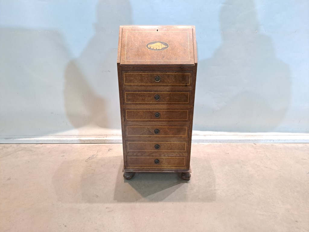 Bureau is a classic type of desk also known as a secretaire. It combines the functions of a desk and a chest of drawers or chest of drawers, ideal for spaces where both a work surface and storage are needed. Rental for events, advertising, series, films.