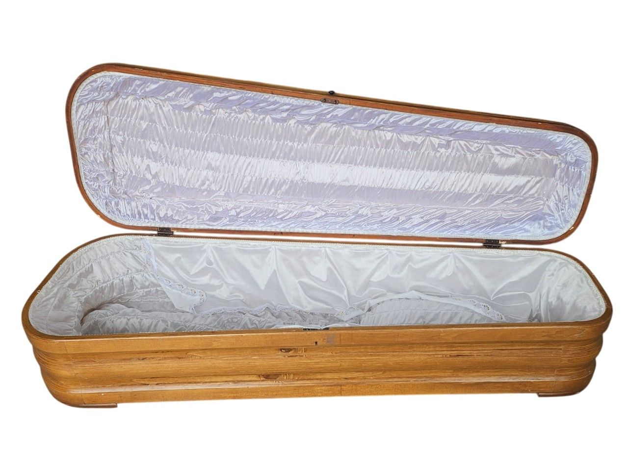 Ataúd de madera de estilo clásico con un acabado natural y una cruz metálica en la tapa alquiler para eventos, publicidad, peliculas y series
