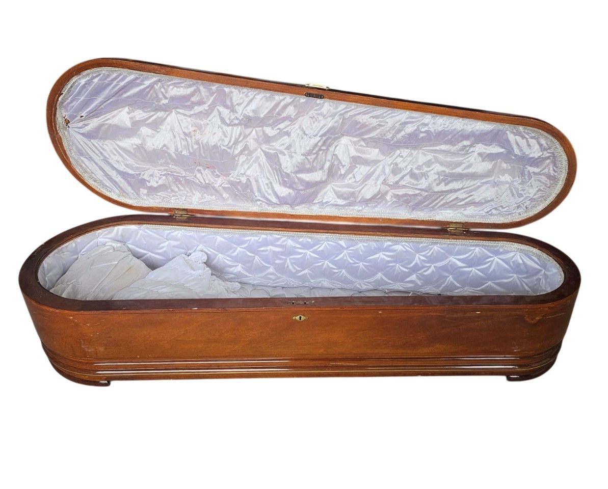 Ataúd féretro de madera fúnebre con un acabado barnizado de alto brillo, comúnmente conocido como arca redonda o de forma elíptica alquiler para eventos, publicidad, peliculas y series