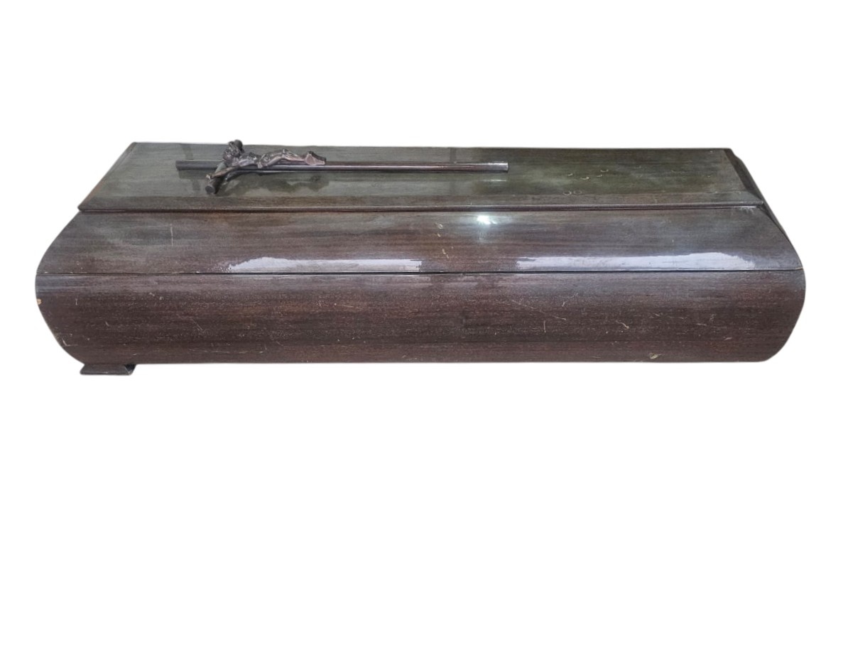Ataúd de madera con un acabado oscuro y brillante, diseñado para servicios funerarios alquiler para eventos, publicidad, peliculas y series