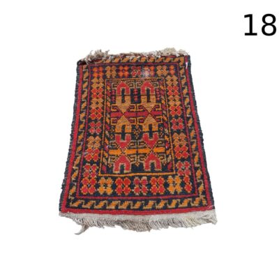 Alfombra baluchi de lana tejida a mano con patrones geométricos y motivos tradicionales en rojo y azul alquiler para eventos, publicidad, peliculas ys eries