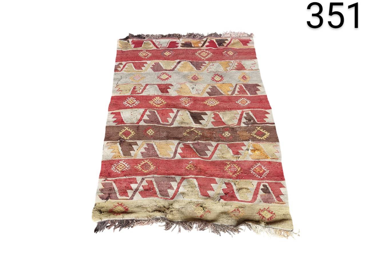 Vintage hand-woven Turkish Kilim rug with vibrant geometric patterns in red, beige and brown tones for rent for events, advertising, films and series.