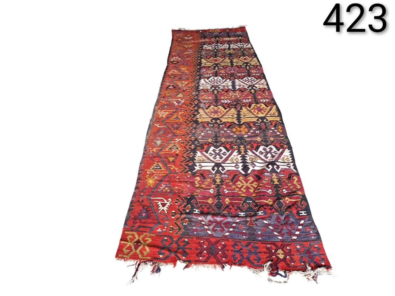 Vintage Turkish Kilim type hand-woven wool corridor rug with geometric patterns in red, brown and blue tones, for rent for events, advertising, films and series.