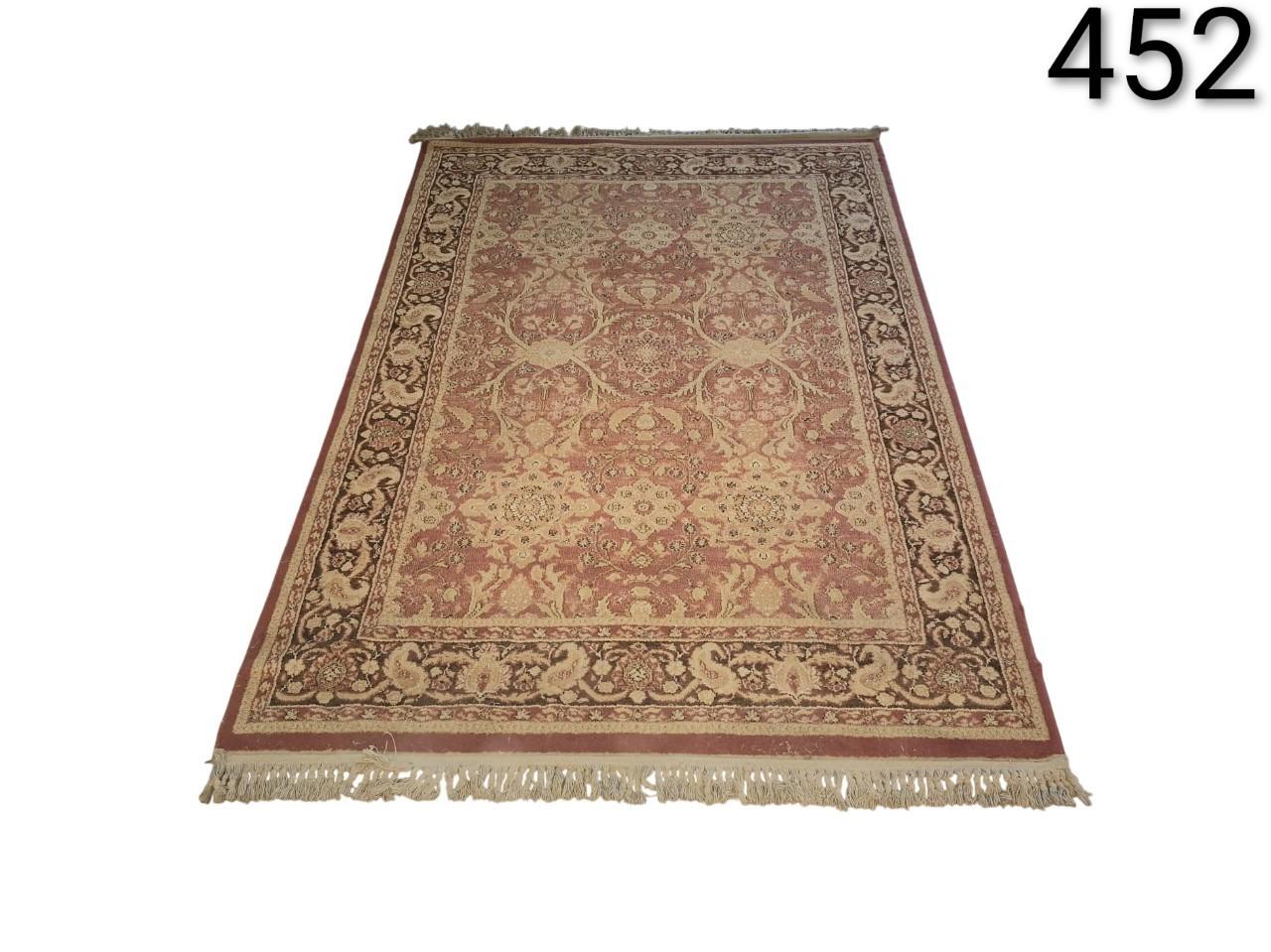 Alfombra anudada a mano con un diseño tradicional de inspiración pakistaní o persa en tonos beige y rojizos alquiler para eventos, publicidad, peliculas y series