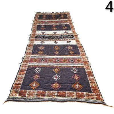 Hand-woven Turkish Kilim rug with geometric patterns in dark brown, orange and white tones for rent for events, advertising, films and series.