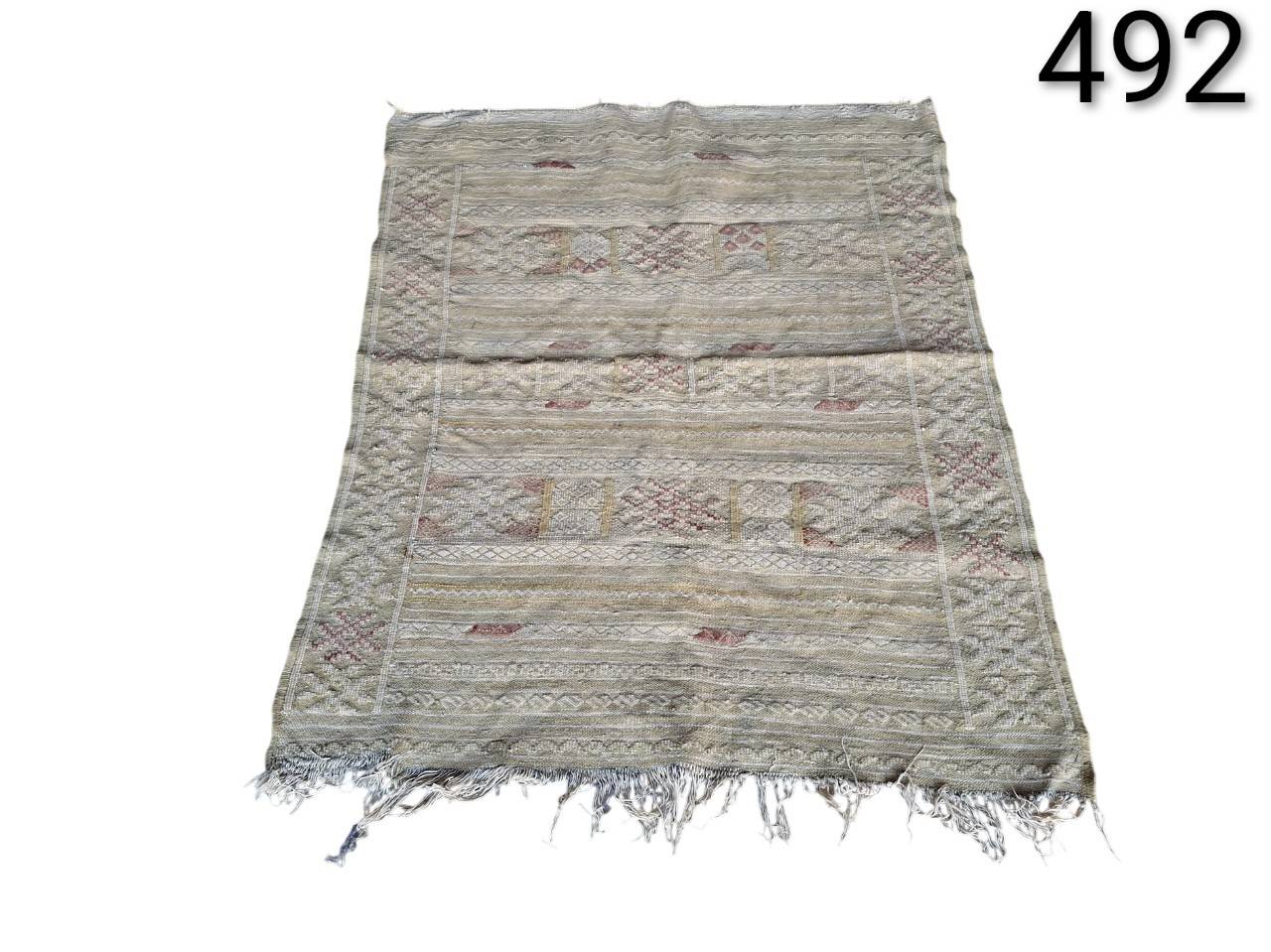 Alfombra Kilim Bereber de lana tejida a mano con un patrón geométrico en tonos neutros beige y gris, probablemente originaria de Marruecos alquiler para eventos, publicidad, peliculas y series