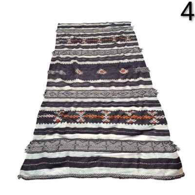 Moroccan Kilim carpet with black and cream stripes and orange geometric patterns for rent for events, advertising, films and series.