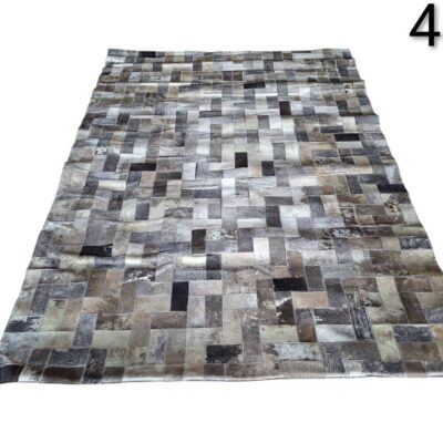 Cowhide rug with patchwork checkered design in grey tones for rent for events, advertising, films and series.
