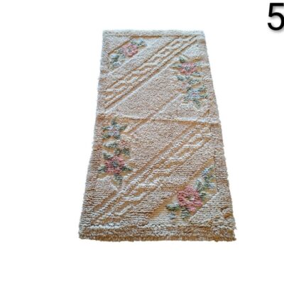 Handmade wool rug with floral design in pink and green tones on a beige background for rent for events, advertising, films and series.