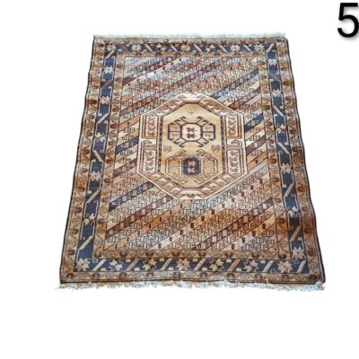 Traditional hand knotted woollen rug with a geometric tribal design and central medallion motifs for hire for events, advertising, films and series.