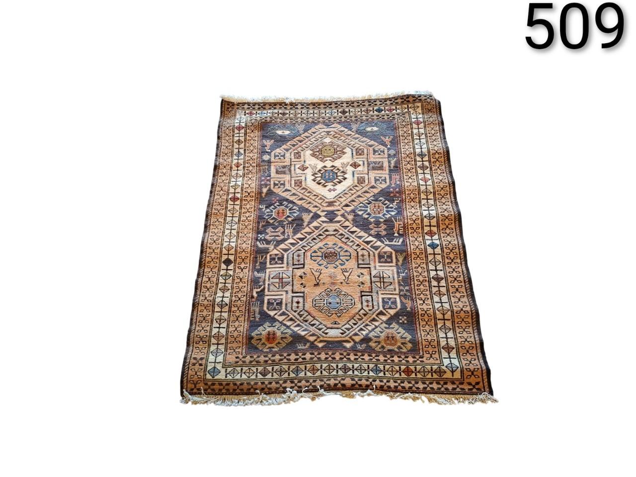 Alfombra parece ser una pieza vintage de lana, posiblemente de origen turco, persa o caucásico, caracterizada por sus patrones geométricos intrincados alquiler para ventos, publicidad, peliculas y series