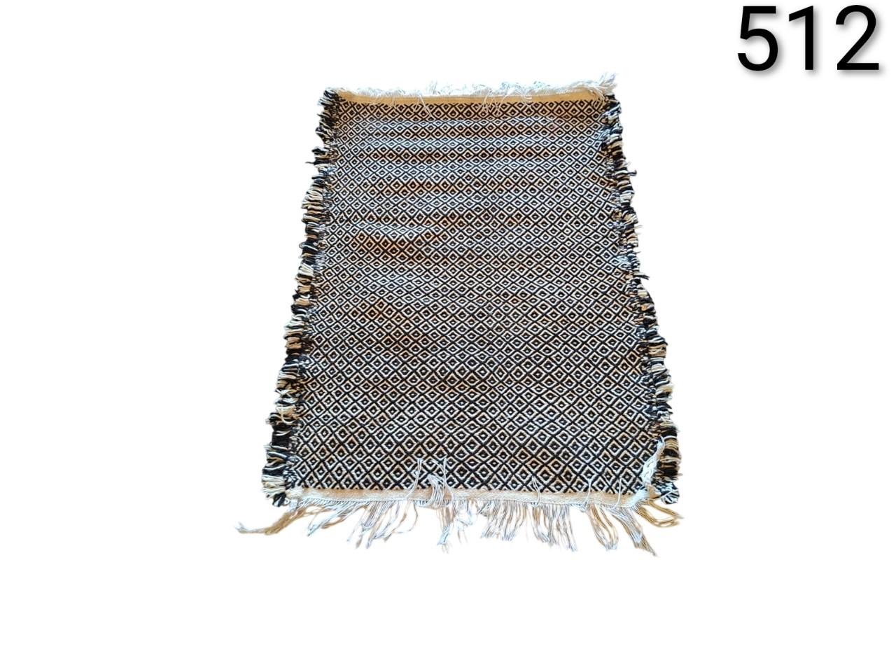 Cotton carpet with fringes and reversible geometric print of black and white rhombuses for rent for events, advertising, films and series.