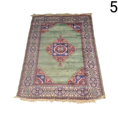 Hand knotted Kazak style rug made in Pakistan, with a central geometric design in red and blue on a pistachio green background for rent for events, advertising, films and series.