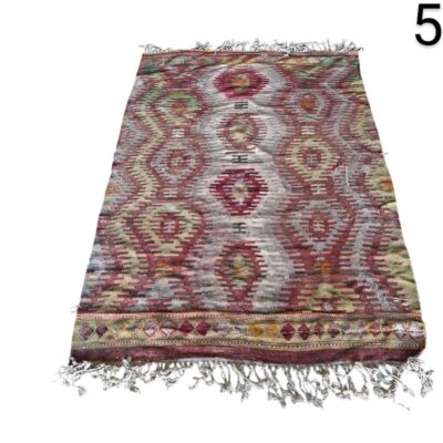 Hand-woven vintage kilim rug with a multicoloured geometric pattern in reddish tones for rent for events, advertising, films and series.