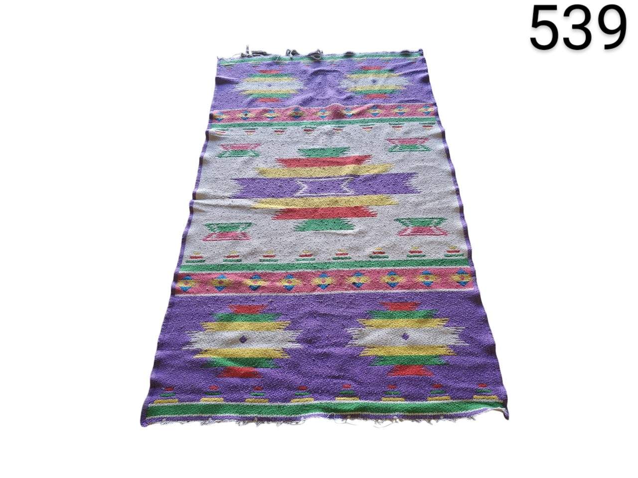 Hand-woven kilim carpet with multicoloured geometric patterns for rent for events, advertising, films and series.