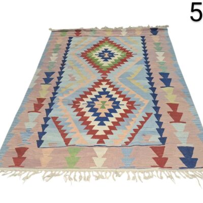 Vintage Turkish Kilim rug with a traditional geometric pattern in pastel and blue tones for rent for events, advertising, films and series.