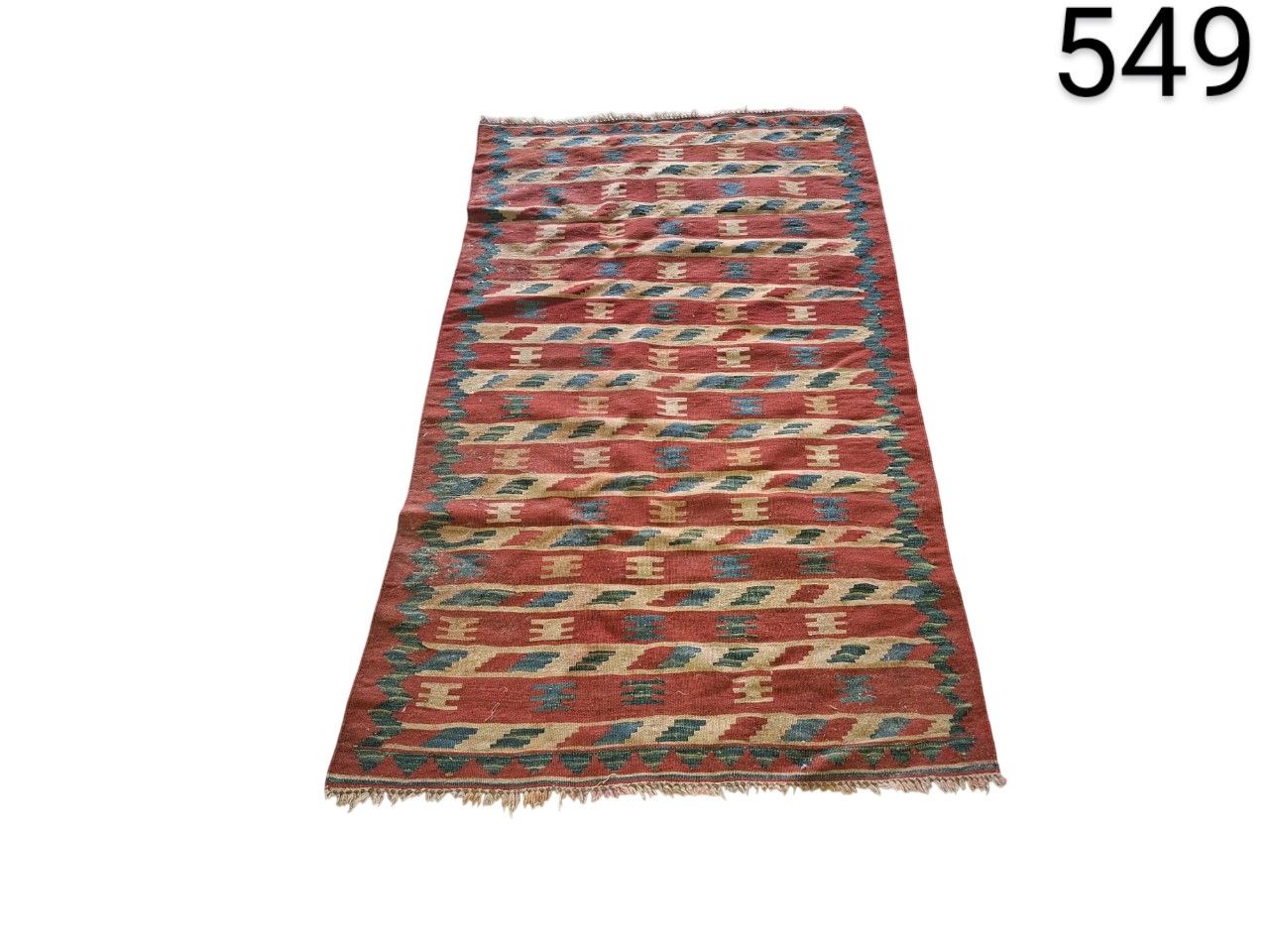 Alfombra Kilim artesanal de color rojo con patrones geométricos azules y beige alquiler para eventos, publicidad, peliculas y series