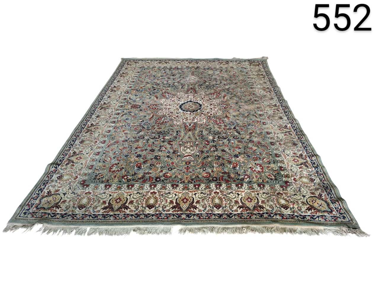 Alfombra persa de estilo tradicional con un intrincado diseño floral y un medallón central en tonos azules, verdes y burdeos alquiler para eventos, publicidad, peliculas y series