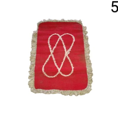 Moroccan style red carpet with white fringes and an embroidered knot design in the centre for rent for events, advertising, films and series.