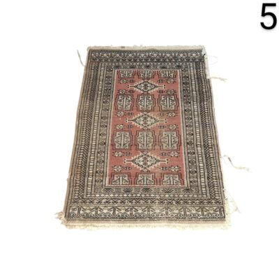 Handmade woollen carpet in Buchara or Pakistan style with geometric patterns in red and black tones for rent for events, advertising, films and series.