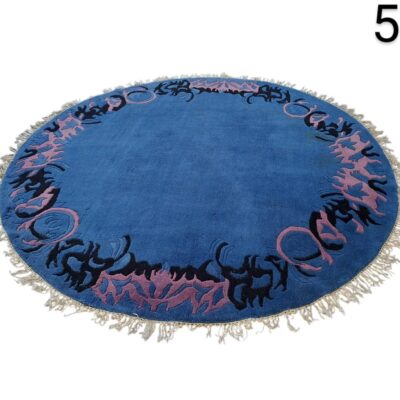 Round Moroccan carpet in deep blue with decorative motifs in lilac and fringes on the border for rent for events, advertising, films and series.