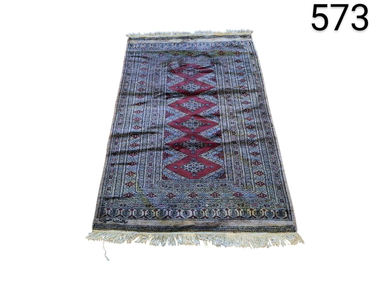 Persian hand knotted woollen carpet with classic Bukhara design in red and beige tones for rent for events, advertising, films and series.