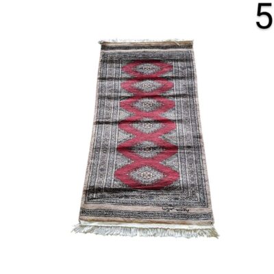 Hand knotted Bokhara type carpet, characterised by its repetitive geometric patterns in red and grey tones, for rent for events, advertising, films and series.