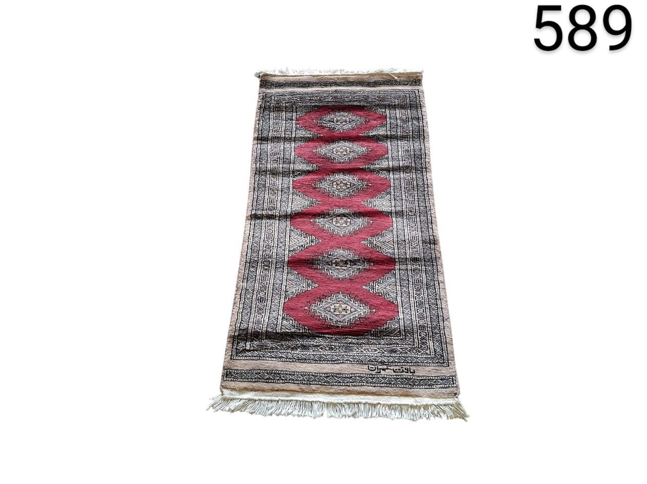 Hand knotted Bokhara type carpet, characterised by its repetitive geometric patterns in red and grey tones, for rent for events, advertising, films and series.
