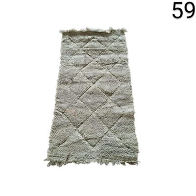 Moroccan hand-woven Beni Ouarain style rug with geometric pattern of diamonds and fringes in ivory or cream tones for rent for events, advertising, films and series.