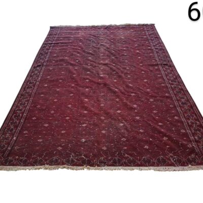 Hand knotted woollen afghan rug with a characteristic burgundy red colour and traditional geometric motifs for rent for events, advertising, films and series.
