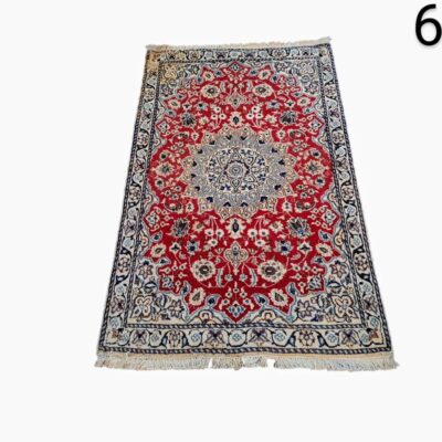 Persian hand-knotted woollen carpet, possibly from the Kashan or Isfahan region, featuring a classic central medallion design in shades of red and blue, rented for events, advertising, films and series.