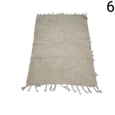 Bohemian style beige carpet with fringes, similar to models made of jute and braided cotton, for rent for events, advertising, films and series.