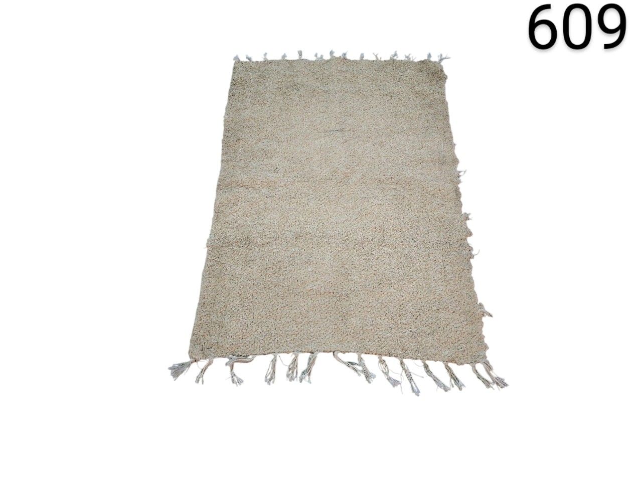 Bohemian style beige carpet with fringes, similar to models made of jute and braided cotton, for rent for events, advertising, films and series.