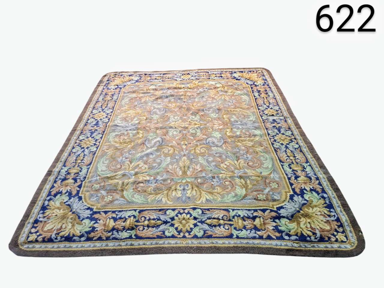 Oriental wool rug, possibly Persian or similar style, characterised by its intricate floral pattern and decorative borders in shades of blue and beige, rental for events, advertising, films and series.