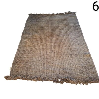 Hand-woven natural jute rug with fringes on the ends for rent for events, advertising, films and series.