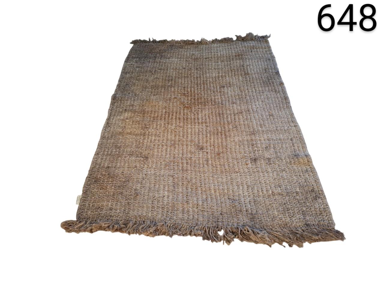 Hand-woven natural jute rug with fringes on the ends for rent for events, advertising, films and series.