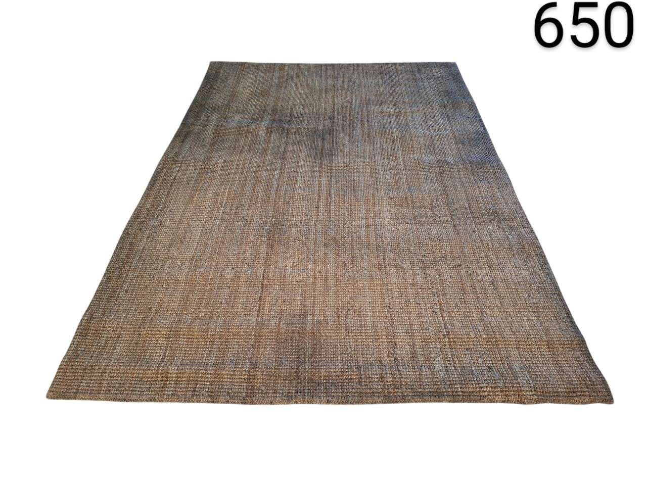 Rectangular rug made of natural fibres, possibly jute or wool, with a woven texture and a worn brown and grey tone, for rent for events, advertising, films and series.