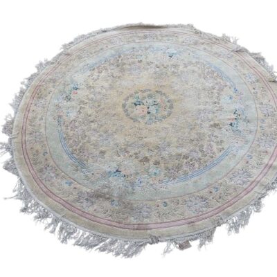Round Persian Tabriz rug in ecru with delicate floral patterns and accents in blue and pink, finished with a fringed border for events, advertising, films and series.