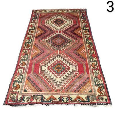 Alfombra Kilim turca tejida a mano, caracterizada por sus patrones geométricos tribales en tonos rojos y marrones alquiler para eventos, publicidad, peliculas y series