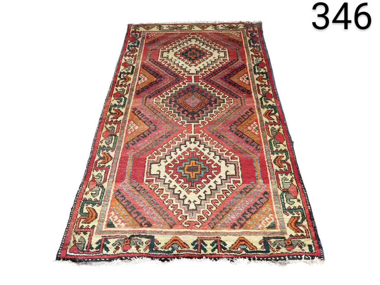 Turkish hand-woven Kilim rug, characterised by its tribal geometric patterns in red and brown tones, for rent for events, advertising, films and series.