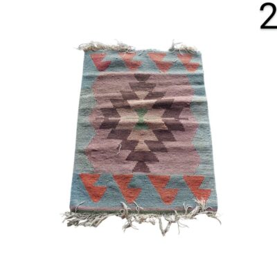 Esta es una alfombra Kilim turca vintage hecha a mano con lana y un patrón geométrico en tonos rosa y verde. alquiler para eventos, publicidad, peliculas y series