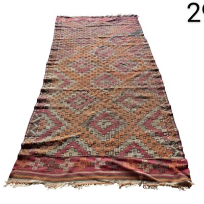 Alfombra Kilim turca vintage tejida a mano con un diseño geométrico en tonos rojos y naranjas alquiler para eventos, publicidad, peliculas y series
